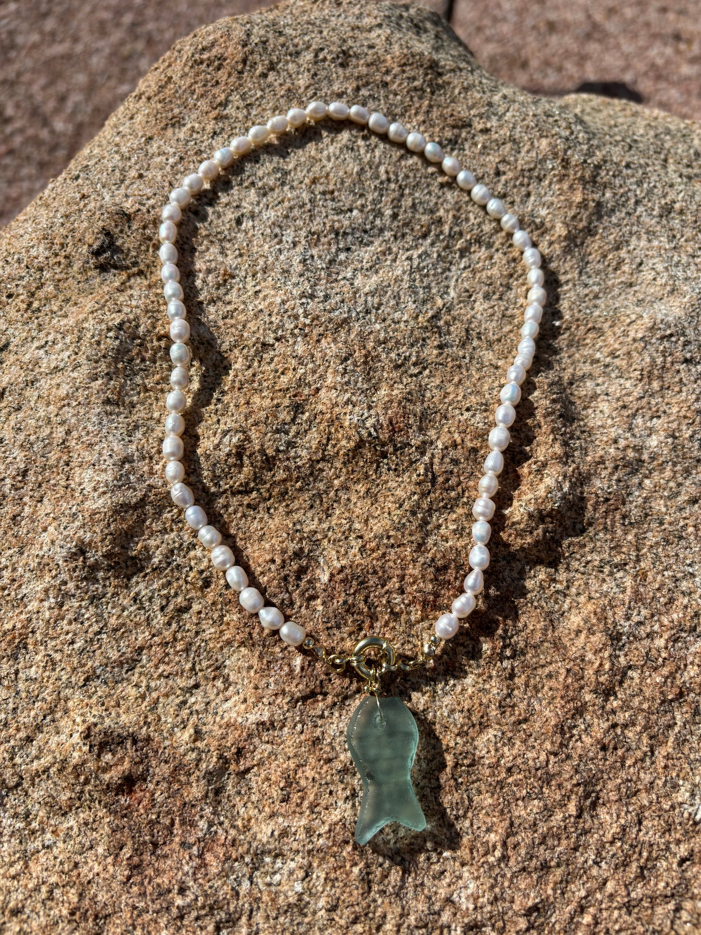 Channel coastal elegance with this freshwater pearl necklace featuring a simulated sea glass fish pendant. Strung on durable silk thread with 14k gold-filled accents, this beach-inspired piece blends ocean charm with timeless sophistication—perfect for mermaid souls and seaside lovers.