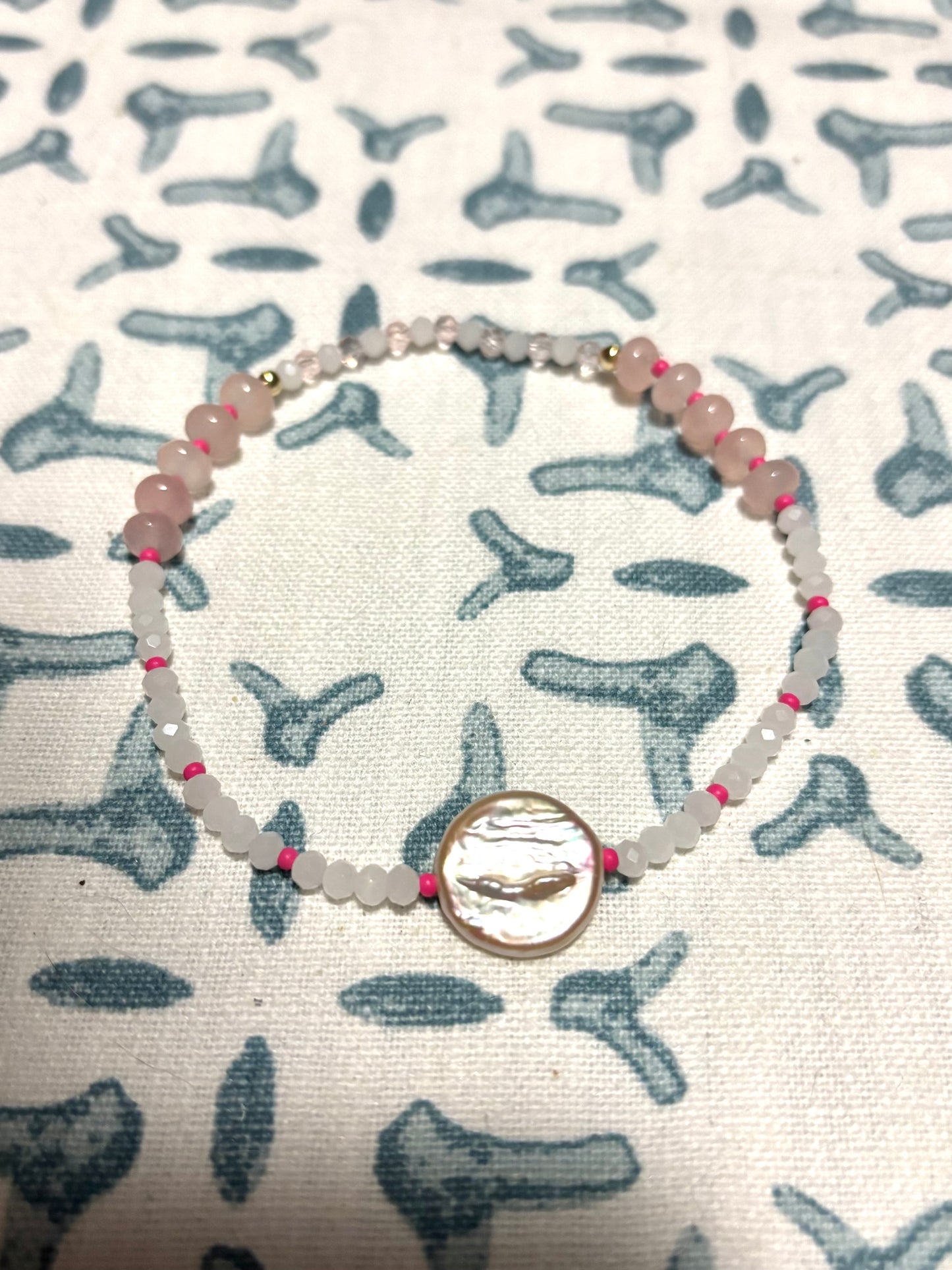 Handmade beaded anklet featuring a lustrous freshwater pearl centerpiece, surrounded by a playful mix of Czech beads, glass beads, soft rose quartz gemstones, and delicate pearls. Finished with 14k gold-filled details for a luxe coastal touch. Perfect for beach-inspired jewelry lovers, this anklet adds a splash of color and elegance to your summer style. Lightweight, feminine, and ideal for layering or wearing solo on sandy shores and sunny getaways.