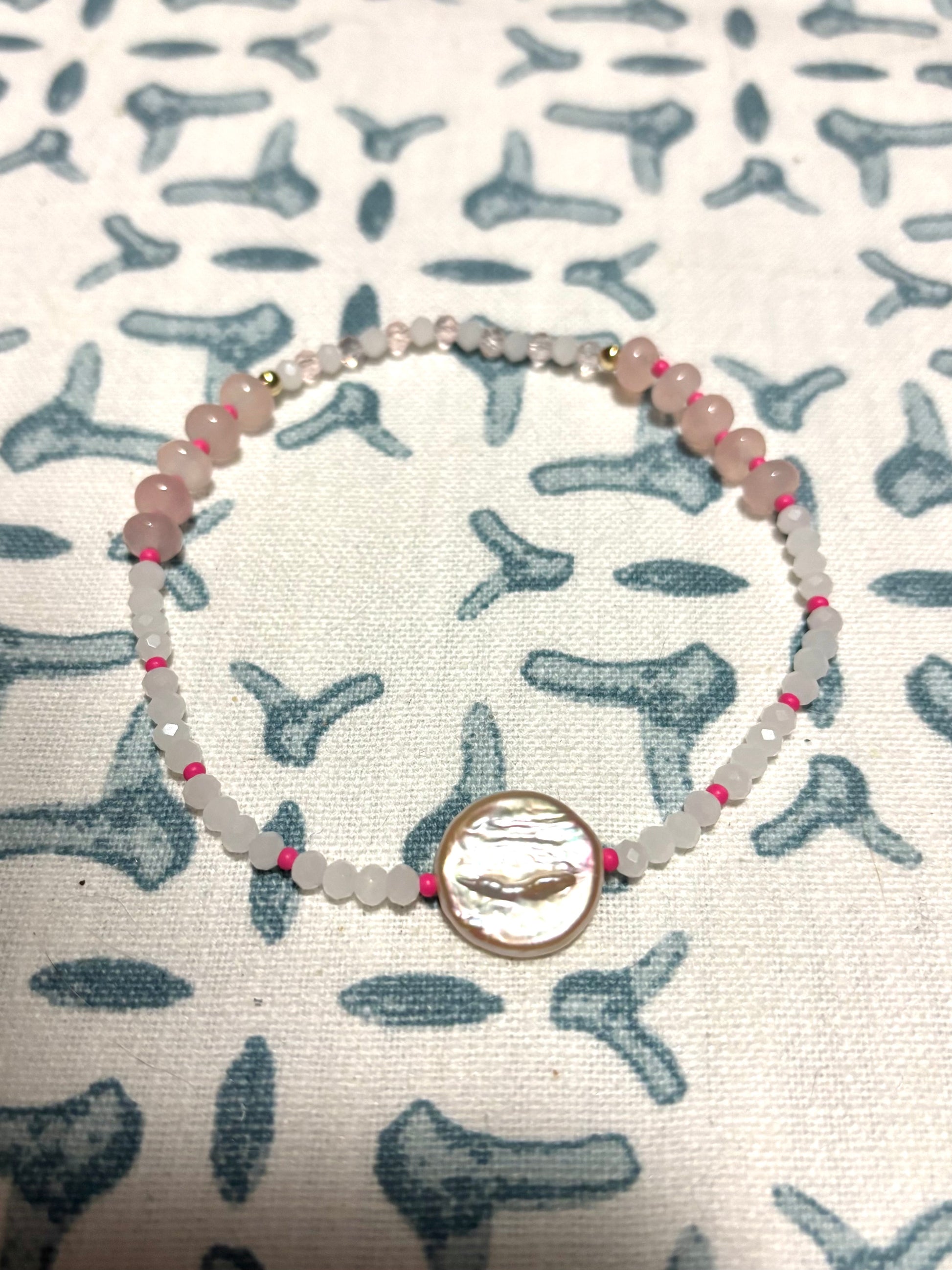 Handmade beaded anklet featuring a lustrous freshwater pearl centerpiece, surrounded by a playful mix of Czech beads, glass beads, soft rose quartz gemstones, and delicate pearls. Finished with 14k gold-filled details for a luxe coastal touch. Perfect for beach-inspired jewelry lovers, this anklet adds a splash of color and elegance to your summer style. Lightweight, feminine, and ideal for layering or wearing solo on sandy shores and sunny getaways.